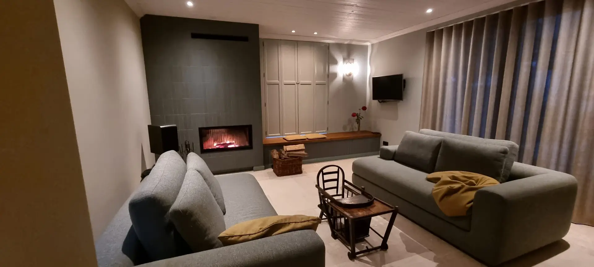Woonkamer met inbouwhaard in een donkere wand