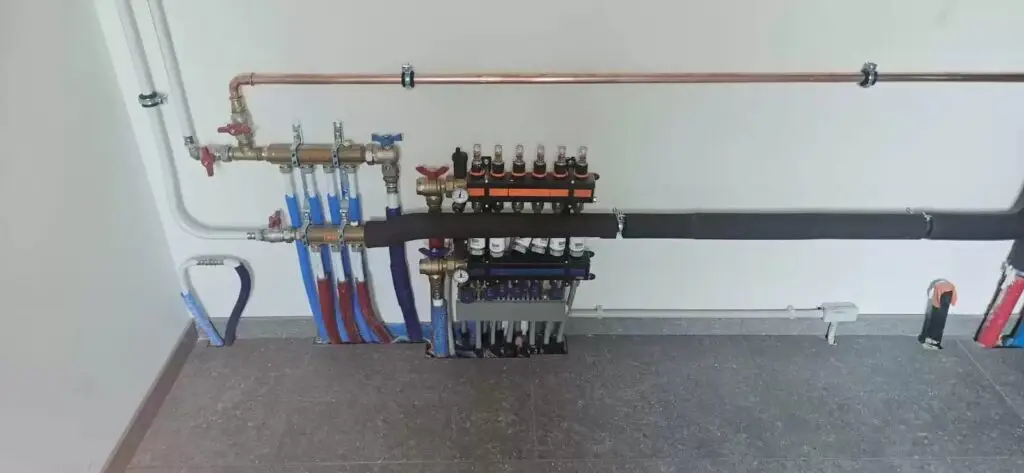 Collector voor de aansluitingen langs de muur, project Warmtepomp met grondboring