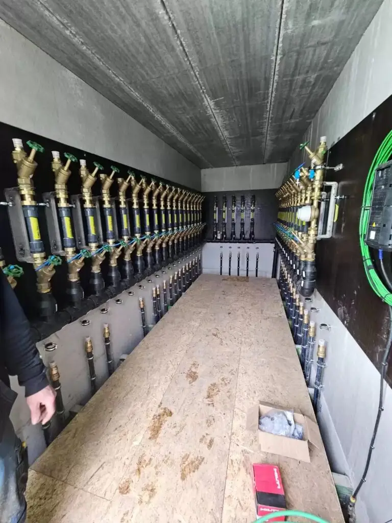 Lange rij aansluitingen in een technische gang, project Brandhaspels en aansluitingen Lichtaart