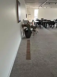 Kantoorruimte met vloerrooster langs de gang, project Ventilatiesysteem Cairox