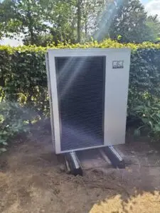 Buitenunit van de lucht-water warmtepomp in de tuin, project Lucht-water warmtepomp in combinatie met Buffer 800liter