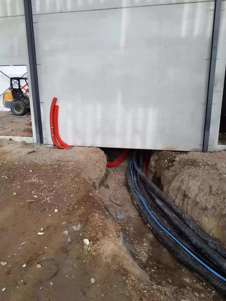 Leidingen in de sleuf langs de hal, project Voorbereidende leidingwerken Pelletketel