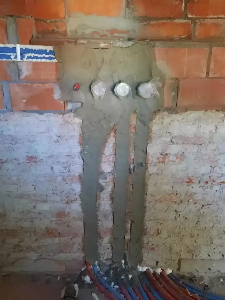Ingewerkte leidingen in de bakstenen muur, project Installatie kapel Turnhout