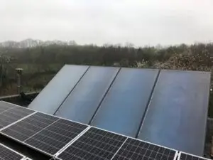 Thermische collectoren en zonnepanelen op een plat dak, realisatie Aqua & Fire
